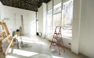 Intérieur en cours de travaux avec grandes fenêtres, typique d'une rénovation maison.