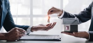 Signature d'un contrat de vente avec une agence immobilière et remise des clés de la nouvelle maison